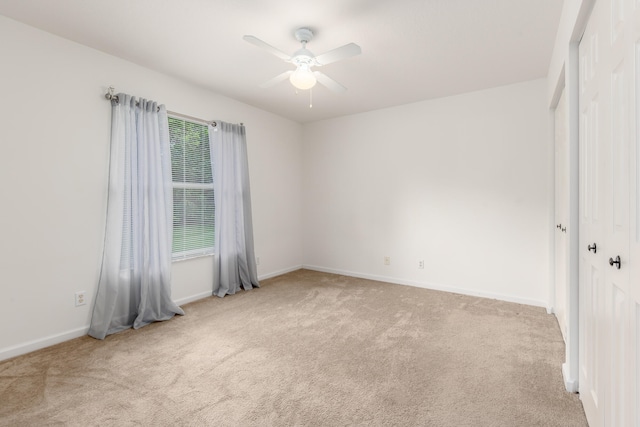 carpeted spare room featuring ceiling fan