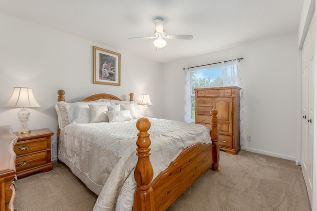 bedroom featuring light colored carpet, ceiling fan, and a closet