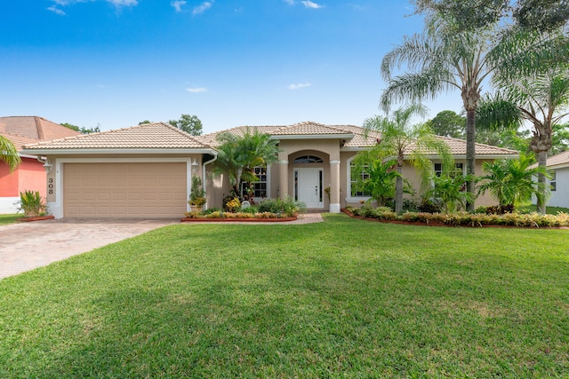 mediterranean / spanish house featuring a garage and a front yard