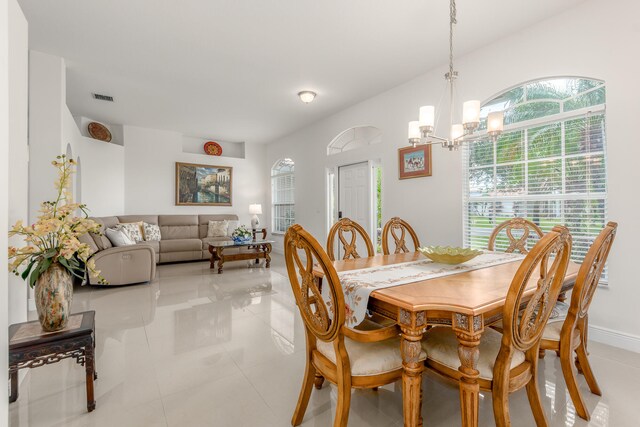 tiled dining area featuring a chandelier and plenty of natural light