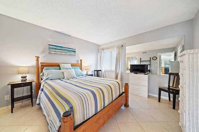 bedroom with light tile patterned floors and a textured ceiling