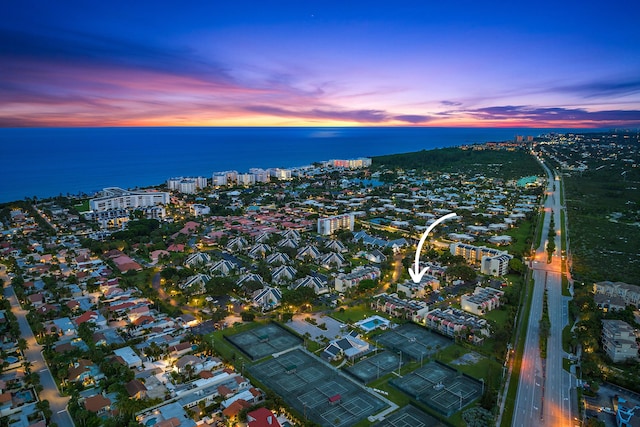 aerial view at dusk featuring a water view