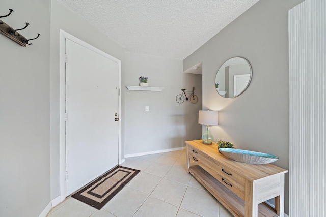 foyer with light tile patterned flooring and a textured ceiling