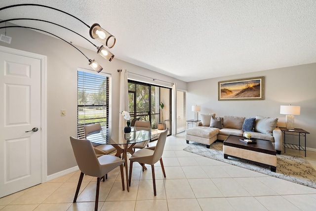 dining area with a textured ceiling and light tile patterned flooring