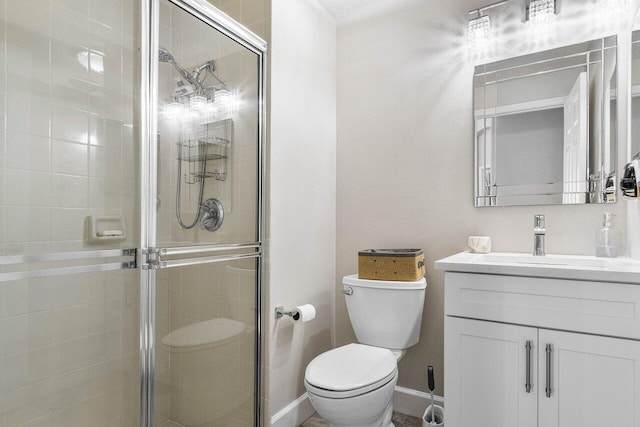 bathroom with vanity, toilet, and a shower with door