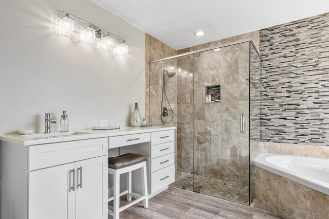 bathroom featuring vanity, hardwood / wood-style flooring, and separate shower and tub