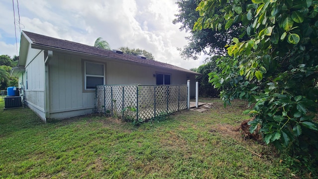 view of property exterior with central air condition unit and a yard