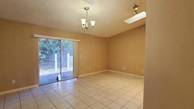 spare room featuring a chandelier, light tile patterned floors, and lofted ceiling with skylight