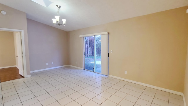 tiled empty room with an inviting chandelier and a skylight