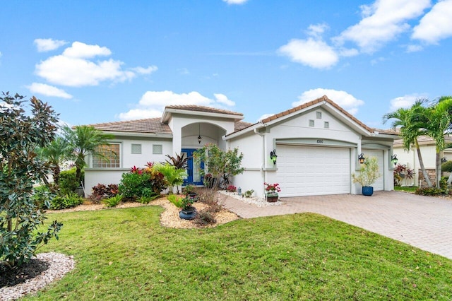 mediterranean / spanish-style home featuring a front yard and a garage