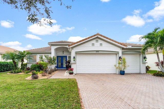 view of front of property featuring a garage, a front yard, and french doors