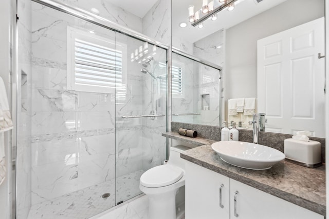 bathroom featuring vanity, toilet, and a shower with door