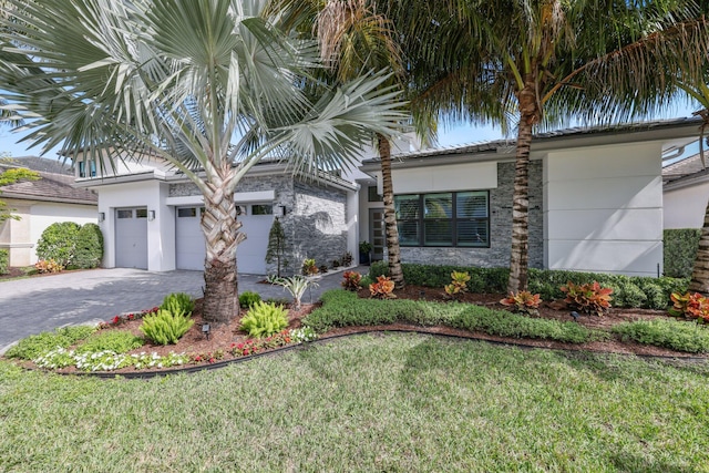 view of front of house with a garage and a front lawn