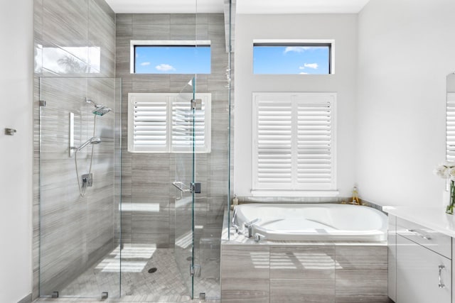 bathroom featuring plenty of natural light and shower with separate bathtub