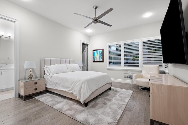 bedroom with connected bathroom, light hardwood / wood-style flooring, and ceiling fan