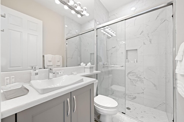 bathroom with vanity, a shower with door, and toilet