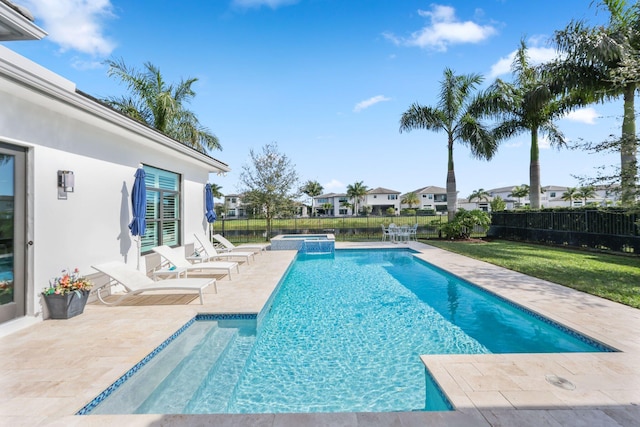 view of pool with a yard, a patio, and an in ground hot tub