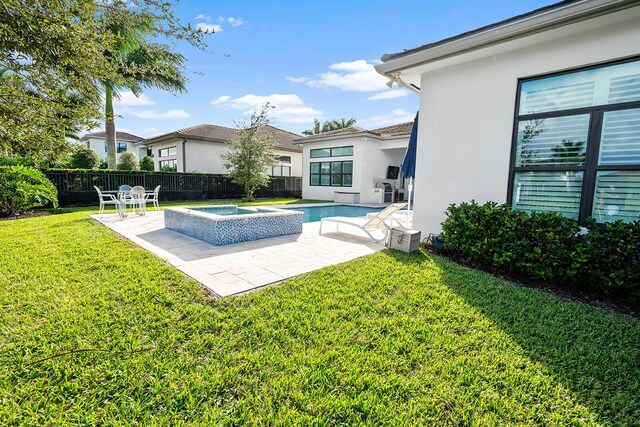 view of pool featuring a yard, a patio, and an in ground hot tub