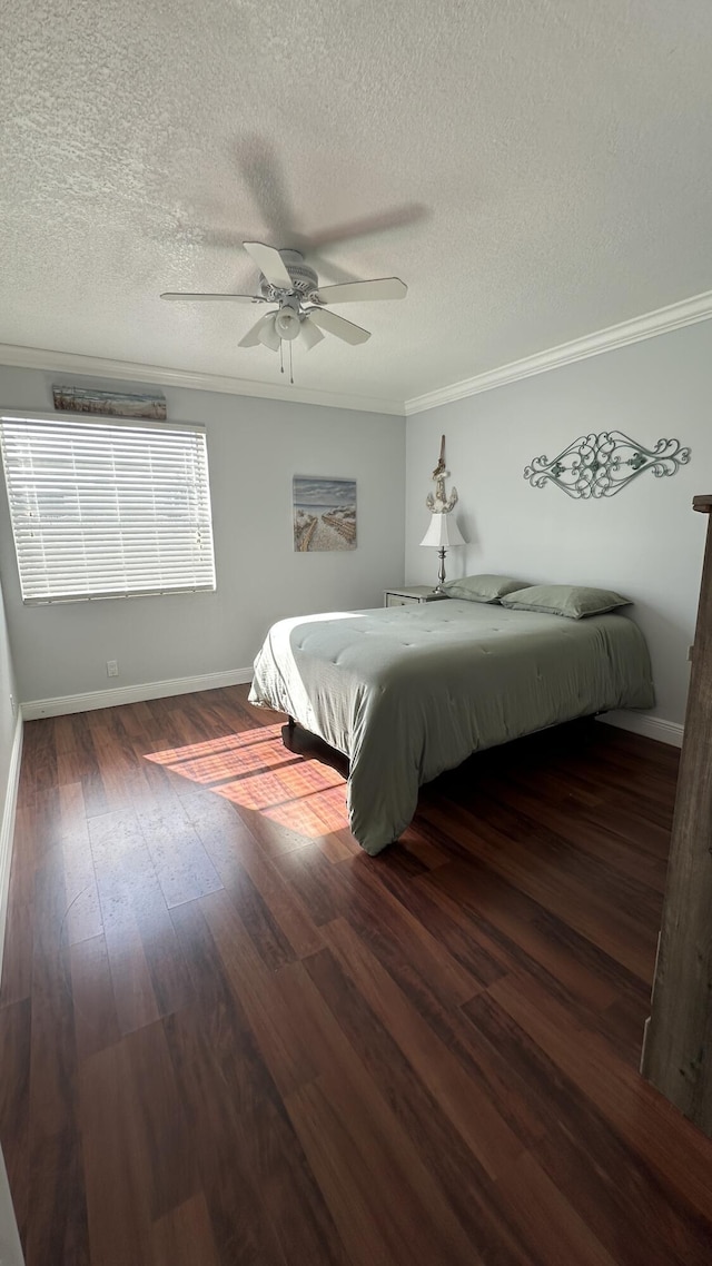 bedroom featuring ornamental molding, dark wood-type flooring, a textured ceiling, and ceiling fan