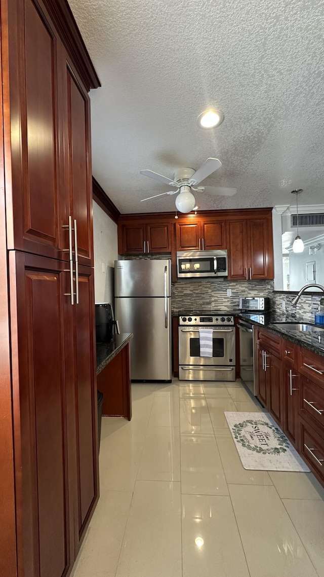 kitchen with pendant lighting, stainless steel appliances, sink, and tasteful backsplash