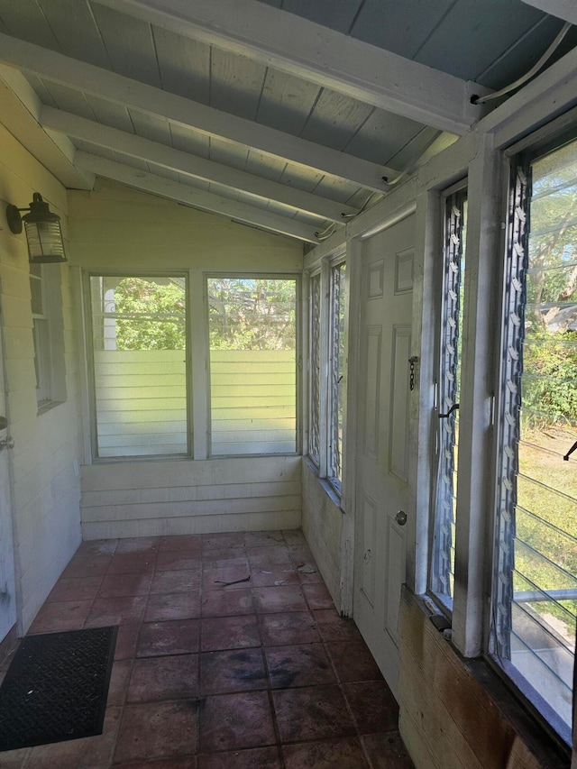 unfurnished sunroom featuring lofted ceiling with beams and wooden ceiling