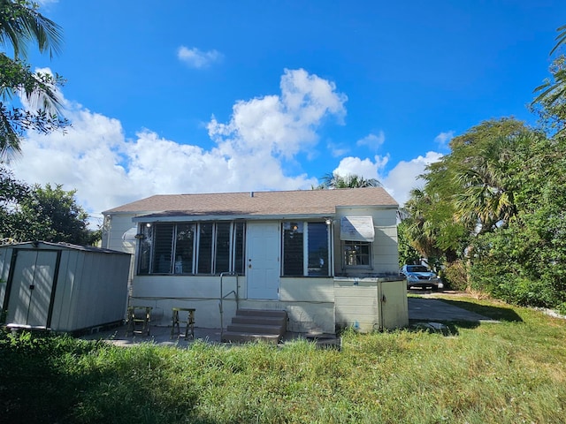 rear view of property featuring a shed