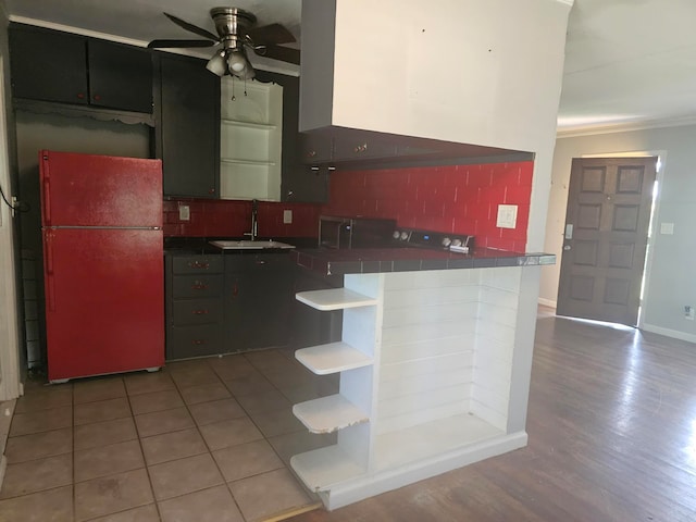 kitchen featuring refrigerator, sink, ceiling fan, backsplash, and light hardwood / wood-style flooring