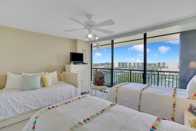 bedroom with ceiling fan, expansive windows, access to exterior, and multiple windows