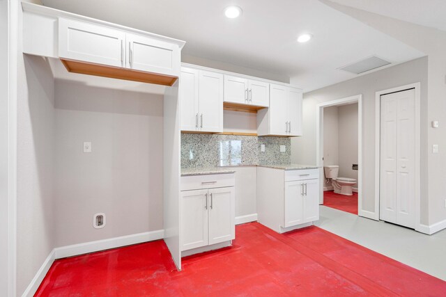 15093 Aguila Ave, Fort Pierce, FL 34951 - kitchen featuring white cabinetry, light stone counters, and backsplash