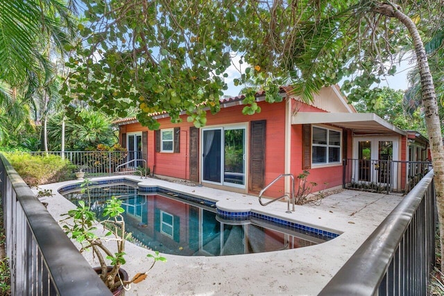 back of property with a fenced in pool and a patio area