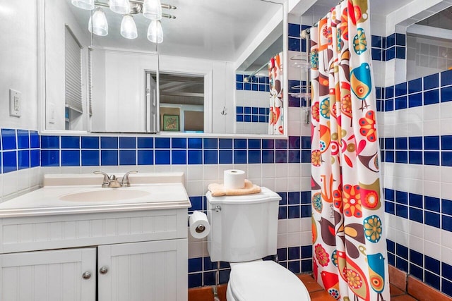 bathroom featuring toilet, vanity, tile walls, and curtained shower