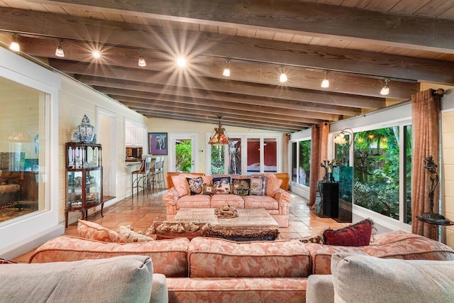 living room with vaulted ceiling with beams, wood ceiling, track lighting, and a healthy amount of sunlight