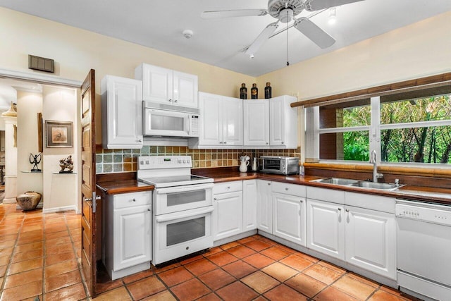 kitchen featuring white appliances, white cabinetry, sink, and backsplash