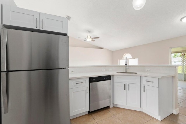 kitchen with stainless steel appliances, light tile patterned flooring, white cabinetry, ceiling fan, and vaulted ceiling