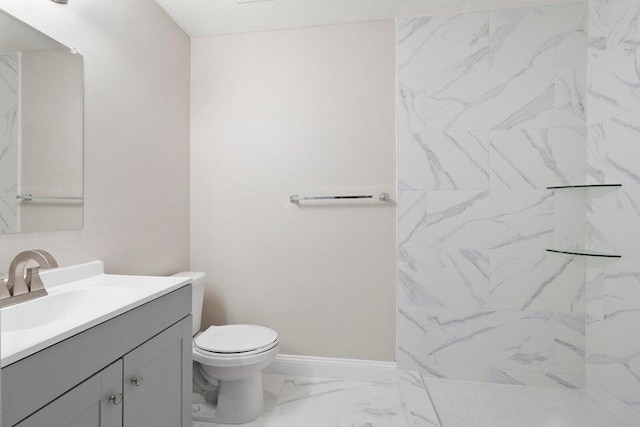 bathroom with vanity, toilet, and a tile shower