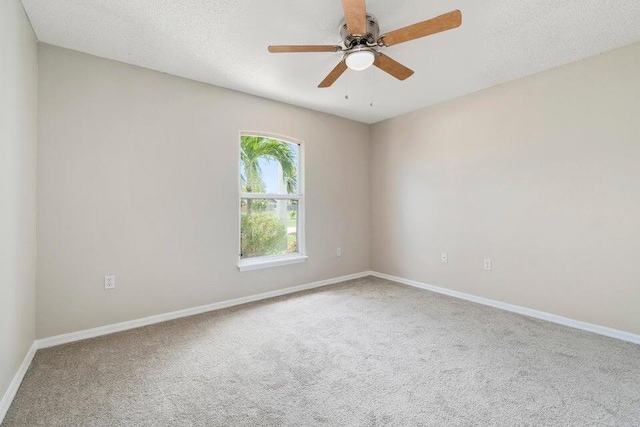 spare room featuring a textured ceiling, carpet floors, and ceiling fan