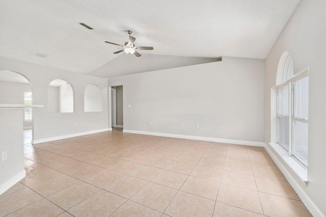 tiled spare room with lofted ceiling, a textured ceiling, and ceiling fan