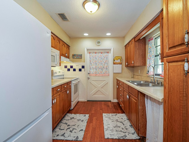 kitchen featuring a textured ceiling, dark hardwood / wood-style floors, white appliances, and sink