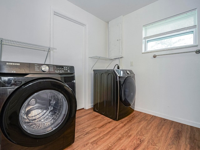 laundry area with independent washer and dryer and light wood-type flooring