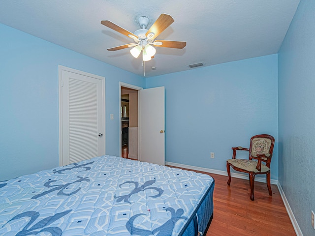 bedroom featuring ceiling fan, a closet, and wood-type flooring