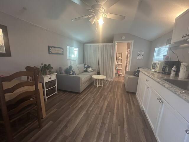 living room featuring ceiling fan, sink, dark hardwood / wood-style floors, and vaulted ceiling