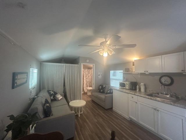 kitchen with white cabinets, sink, vaulted ceiling, dark hardwood / wood-style floors, and ceiling fan