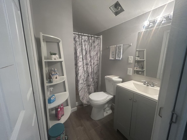 bathroom with walk in shower, vanity, hardwood / wood-style flooring, toilet, and lofted ceiling