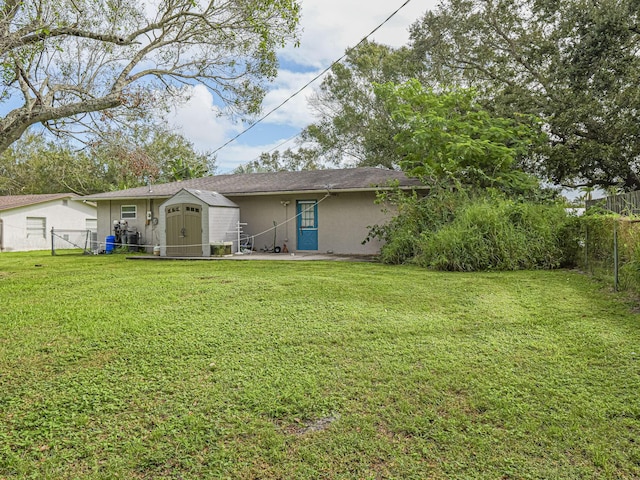 back of property featuring a storage shed and a lawn