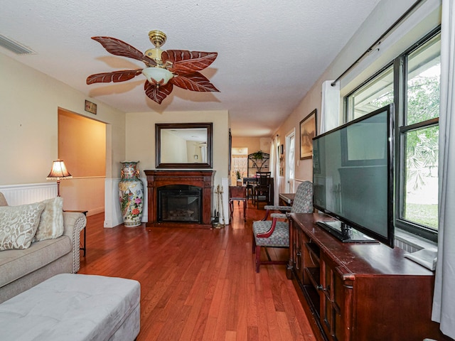 living room with hardwood / wood-style floors, a healthy amount of sunlight, and a textured ceiling