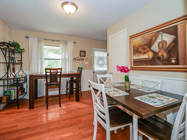 dining room with hardwood / wood-style floors and a textured ceiling