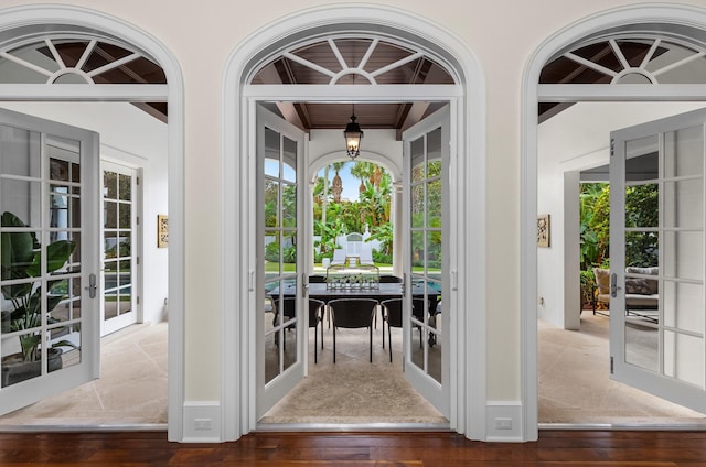 entryway with french doors, beamed ceiling, and wood-type flooring