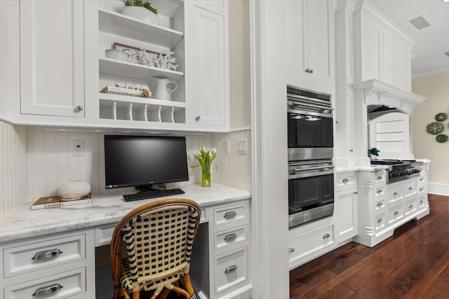 office space featuring ornamental molding, dark wood-style flooring, built in study area, and visible vents