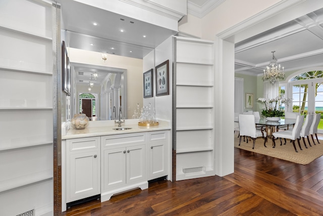 bathroom with a notable chandelier, visible vents, vanity, ornamental molding, and wood-type flooring