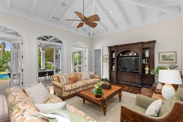 living area featuring ceiling fan, wood finished floors, beamed ceiling, french doors, and high vaulted ceiling